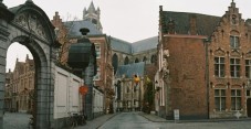 Historic European street view leading towards a large gothic cathedral.